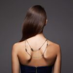 Femme portant un collier de dos avec une robe élégante au dos nu.